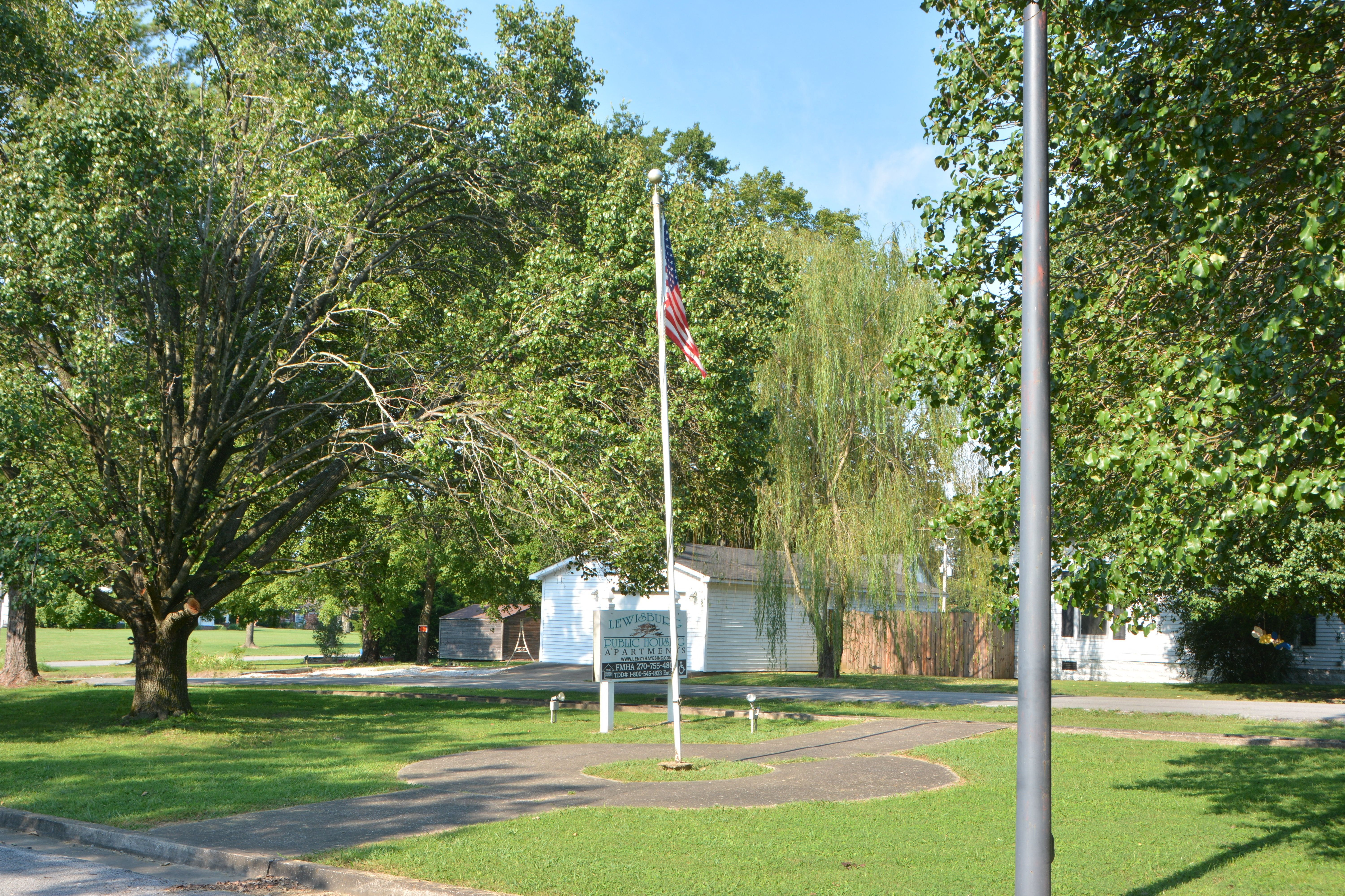 a flag pole with an flag in a park